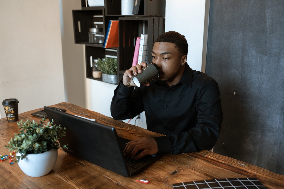 Homem trabalhando home office tomando café
